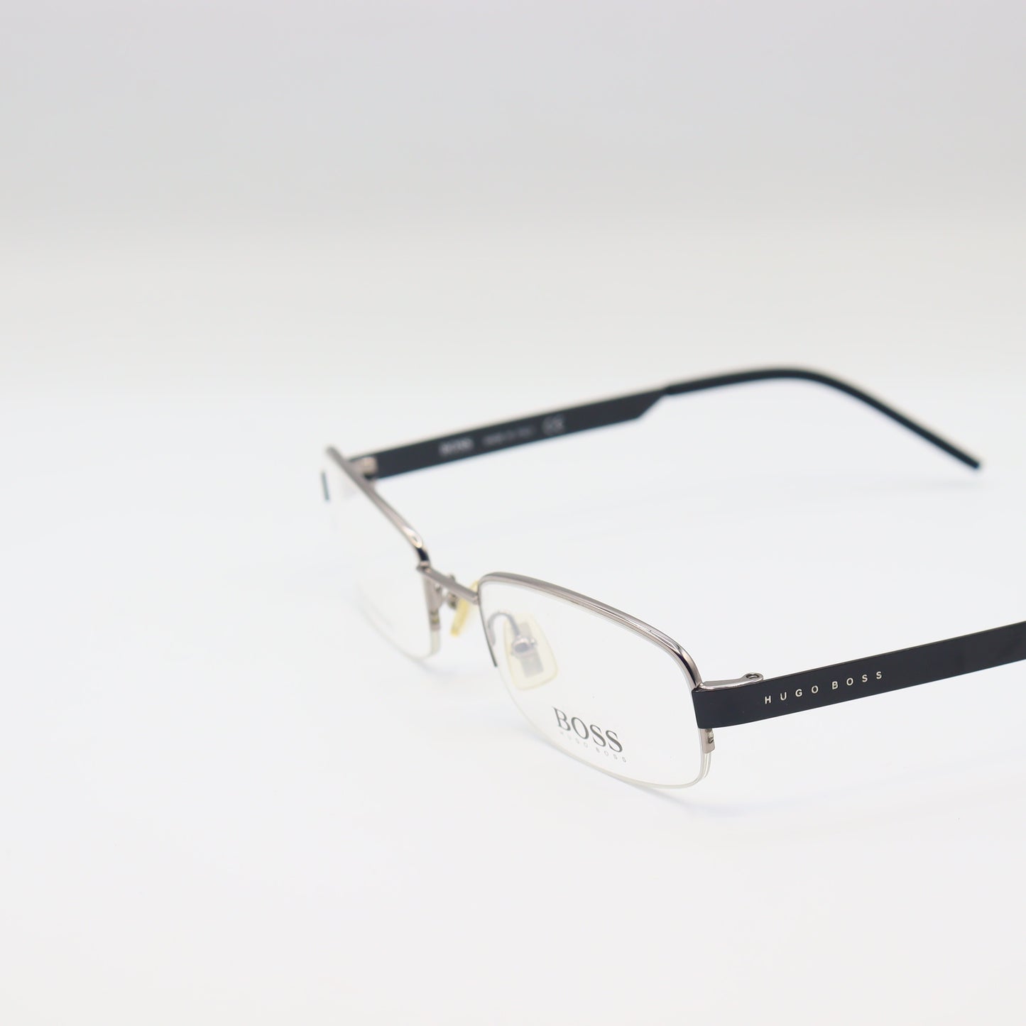 Chashmay Khas® rectangular Hugo Boss stainless steel eyeglasses with silver and black frames placed on a white background.